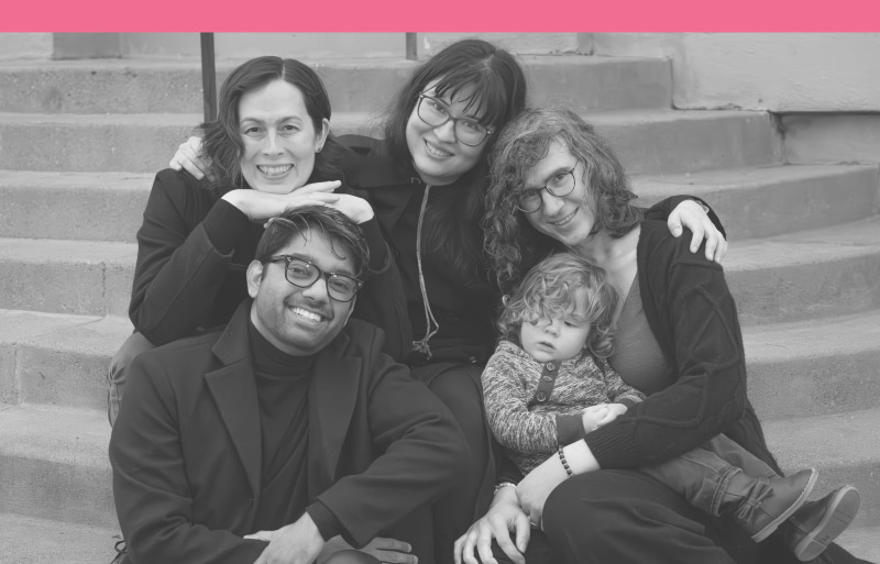Photo of four parents with one child together on outdoor stairs